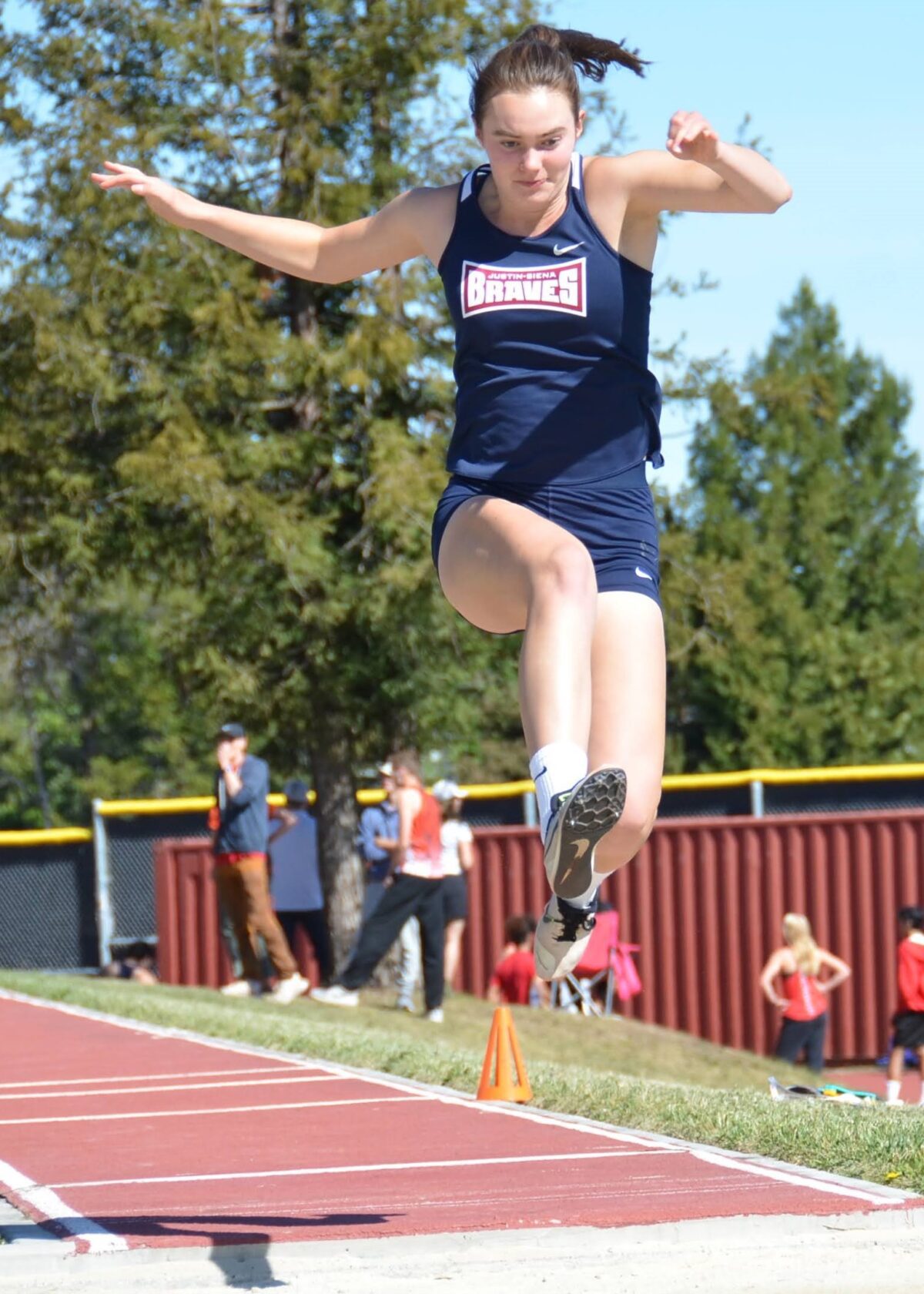 Female long jumper midair on track runway