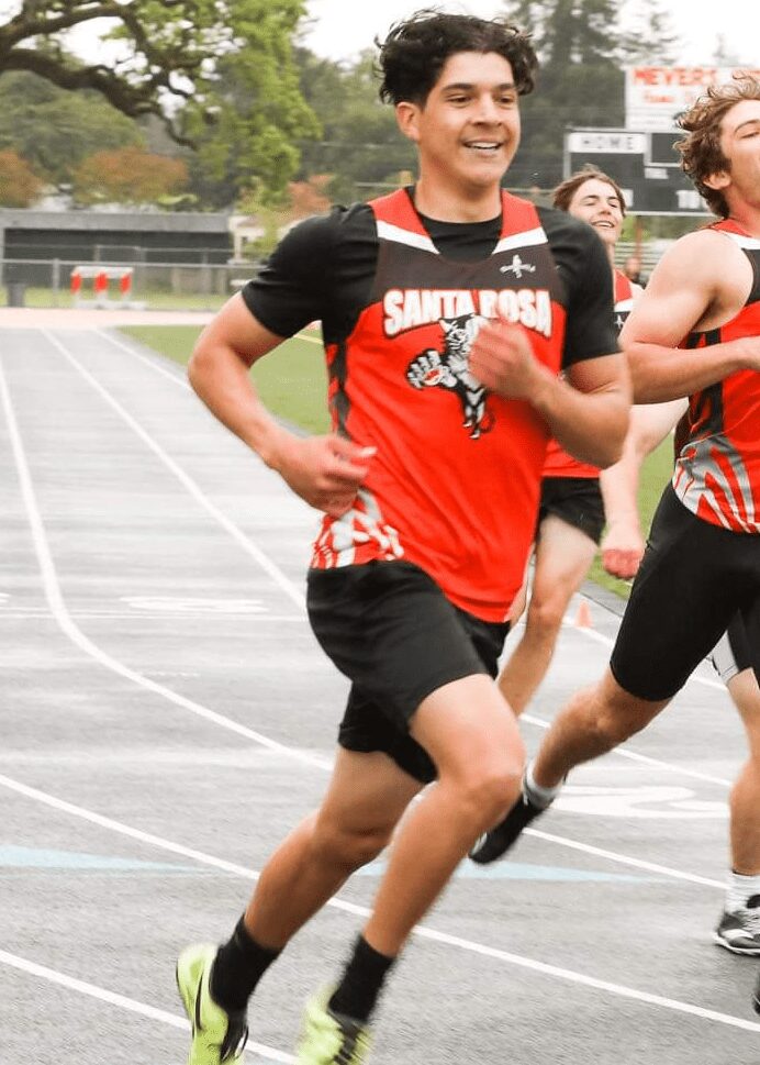 Athlete sprinting on track in red uniform
