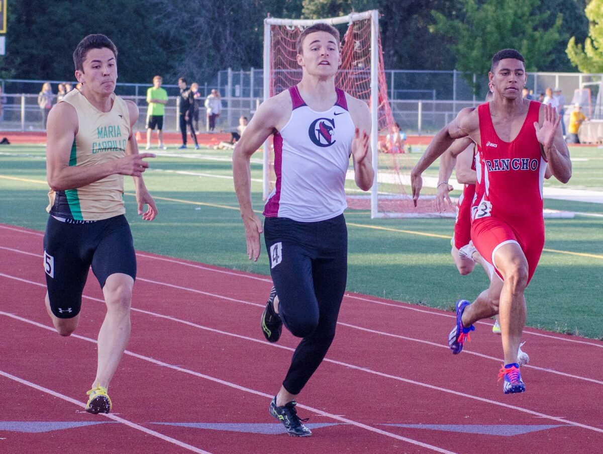 Three sprinters racing in outdoor track meet