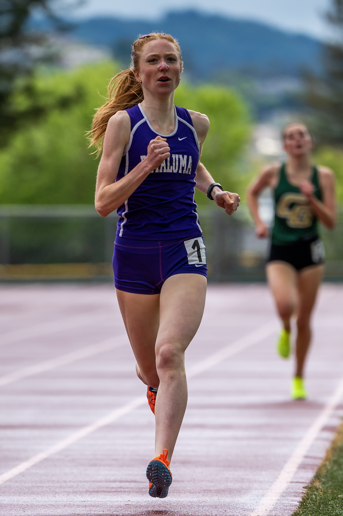 Female runner in purple sprinting on outdoor track