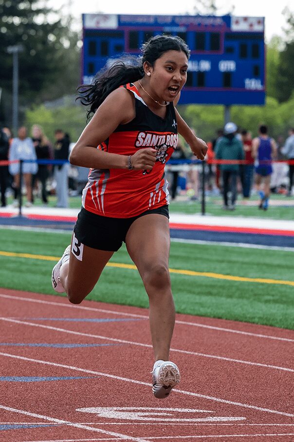 Athlete sprinting on outdoor track in red