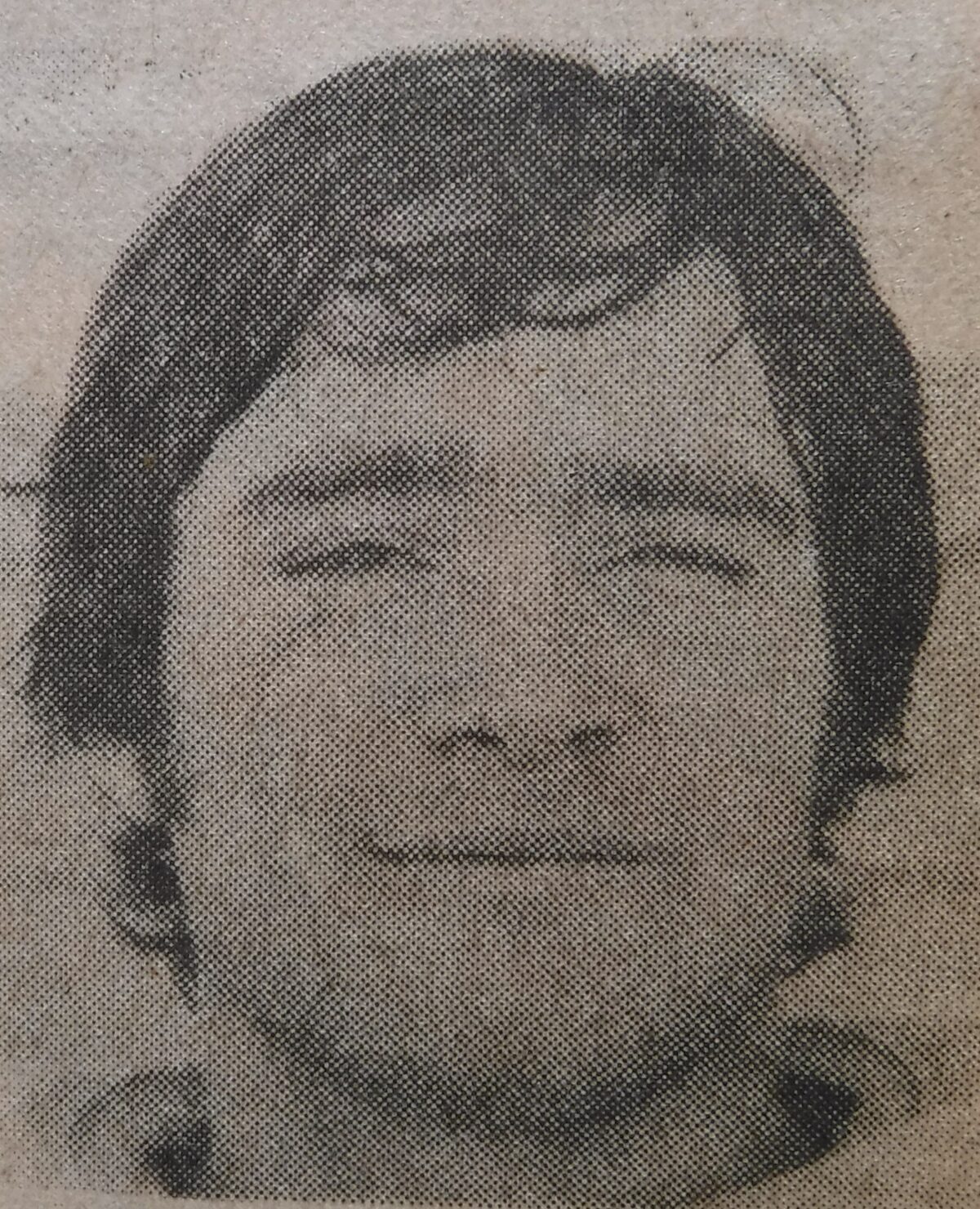 Grainy newspaper-style portrait of smiling man