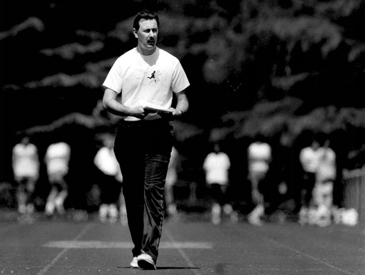 Man walking on running track holding papers