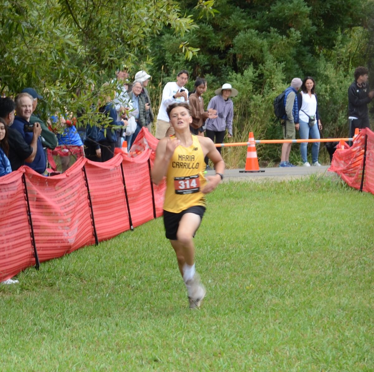 Runner sprinting on grassy cross-country course