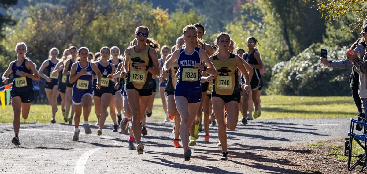Women cross country runners racing on trail