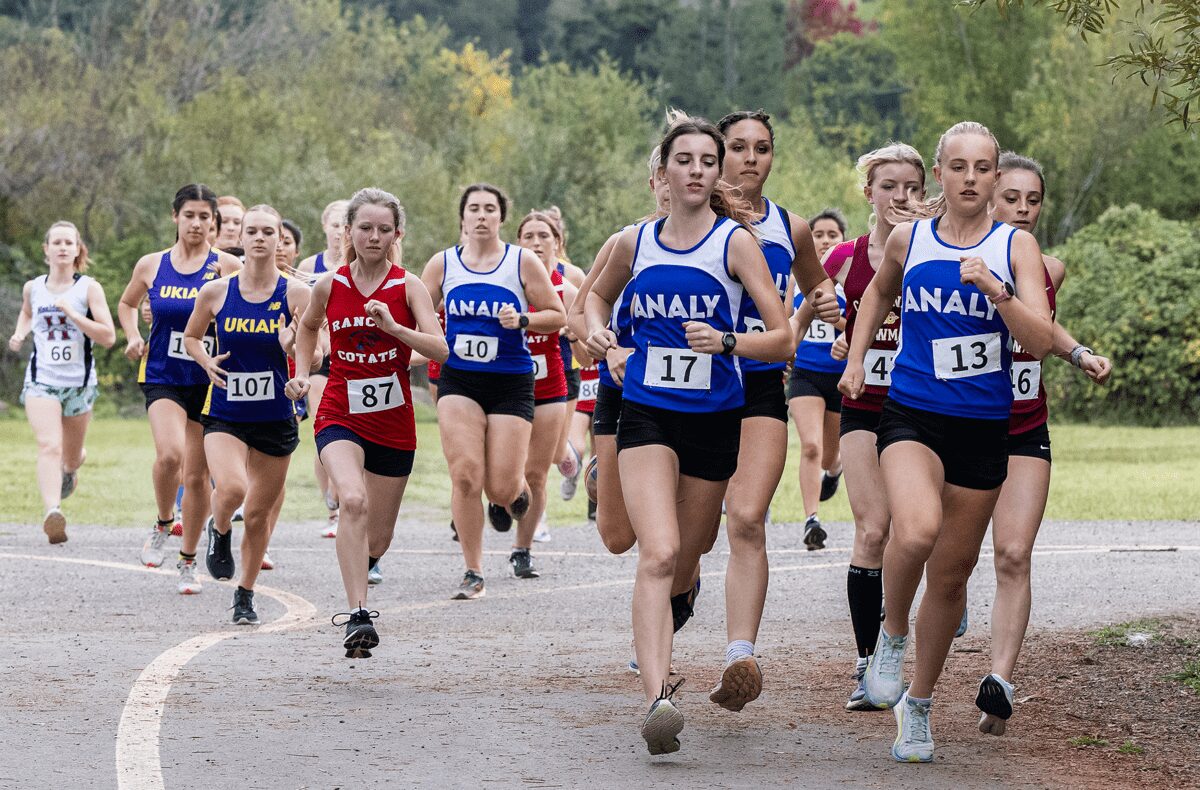 Female cross-country runners racing on trail