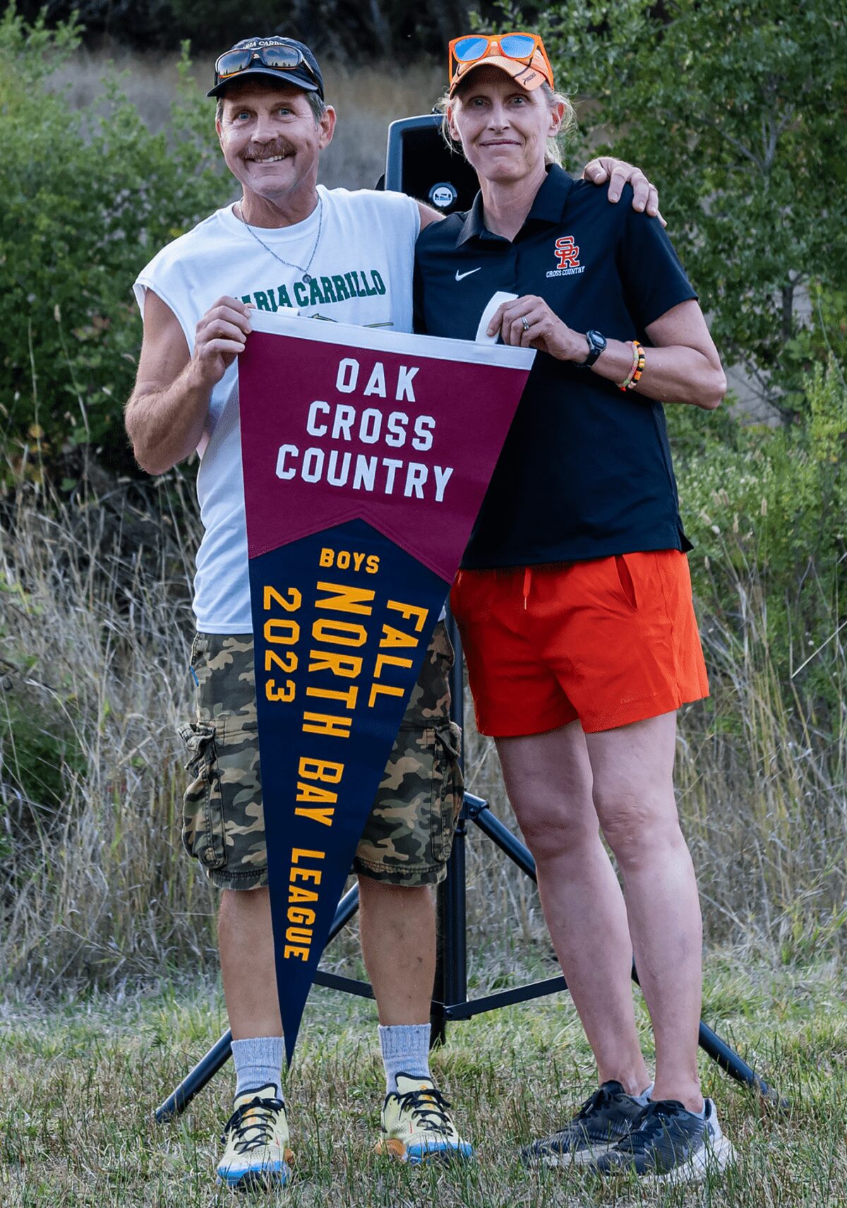 Two adults holding cross country pennant