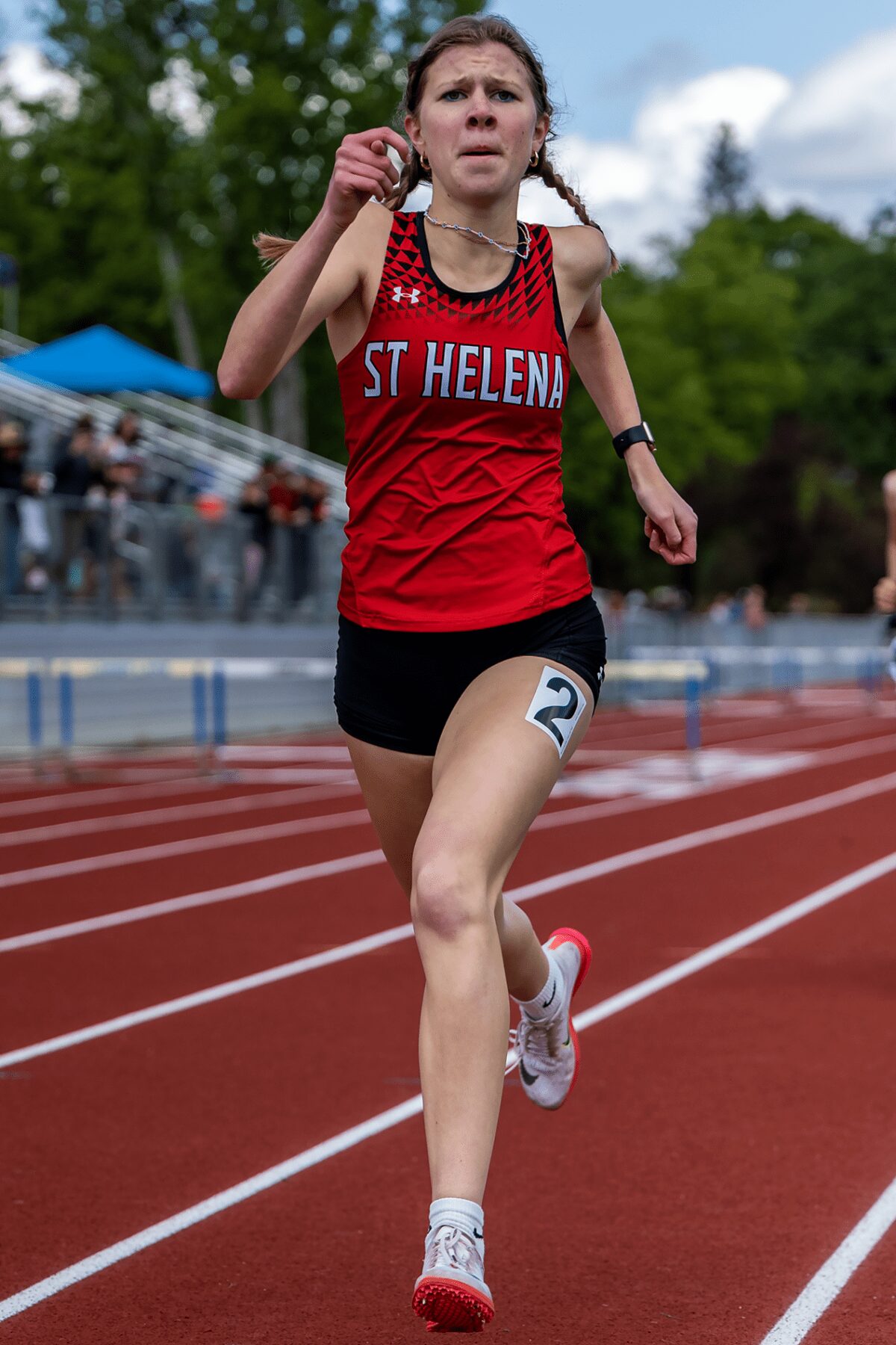Track runner in St. Helena uniform sprinting