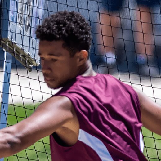 Athlete reaching near volleyball net outdoors
