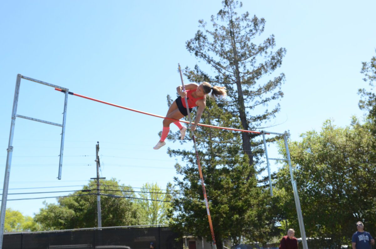 Athlete pole vaulting over bar outdoors