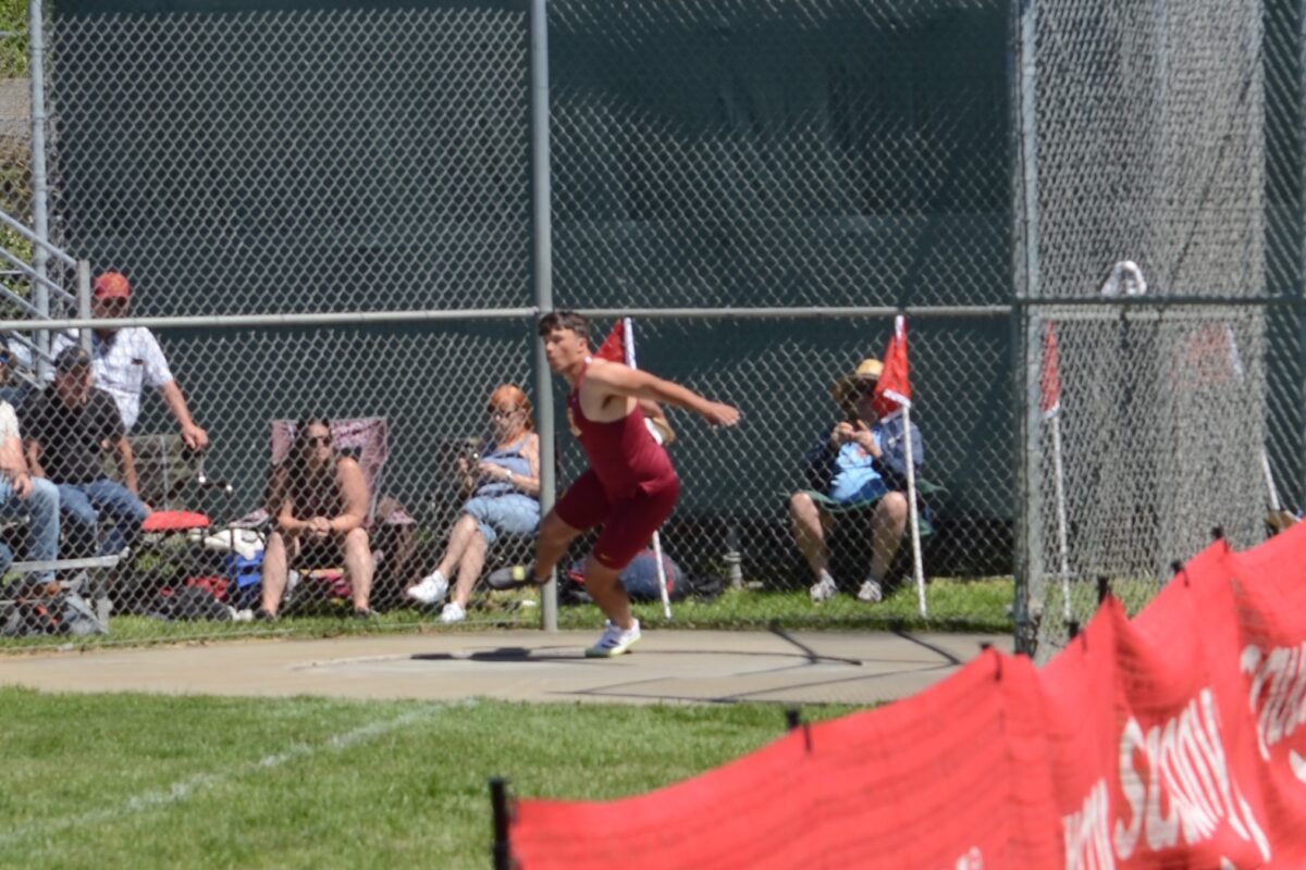 Athlete throwing discus at outdoor track meet