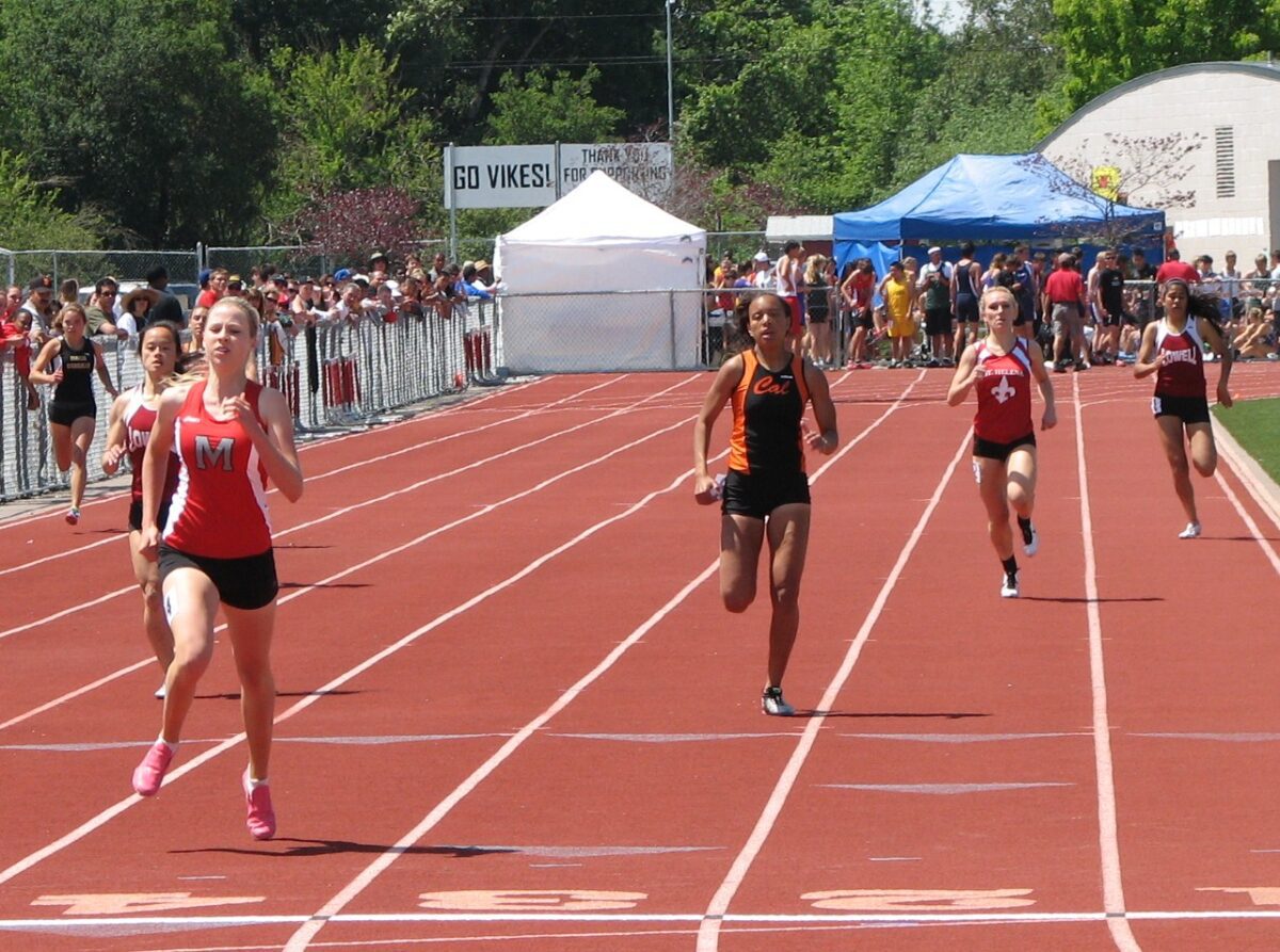 Female sprinters racing on outdoor track