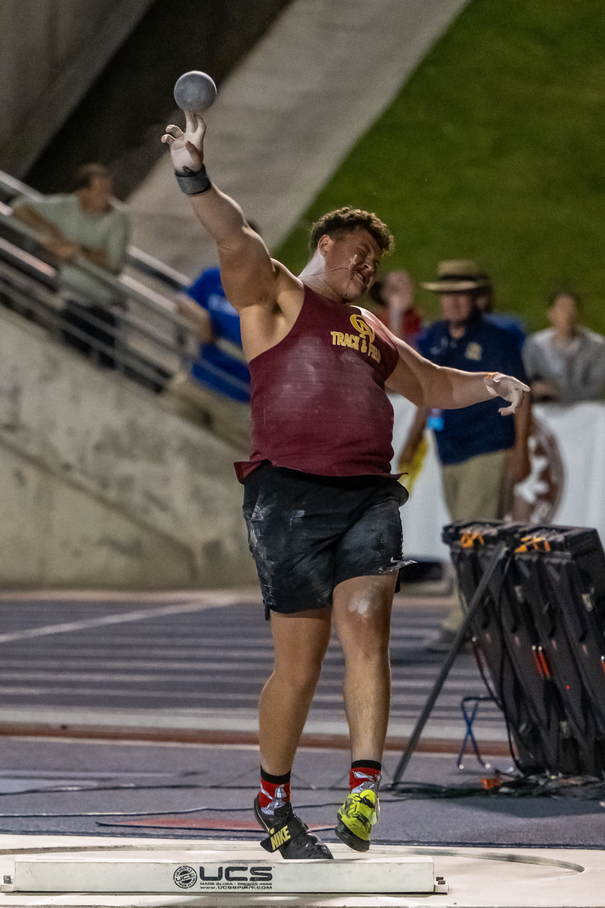 Shot put athlete releasing throw on track
