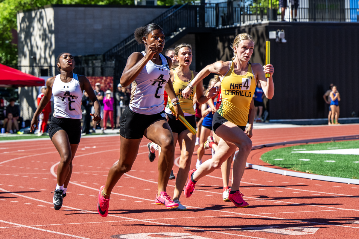 Female sprinters competing in relay race