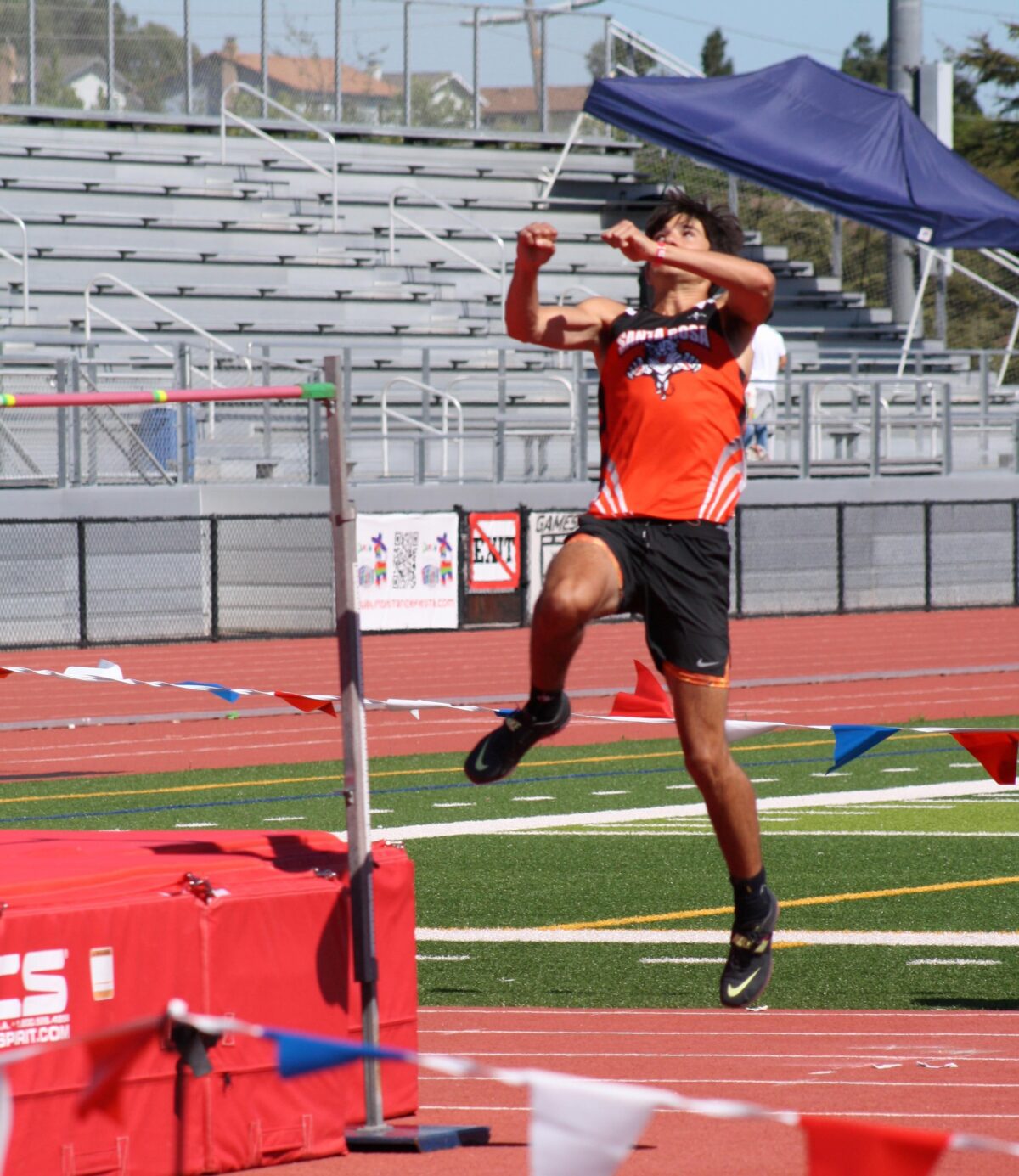High jumper midair over bar on track