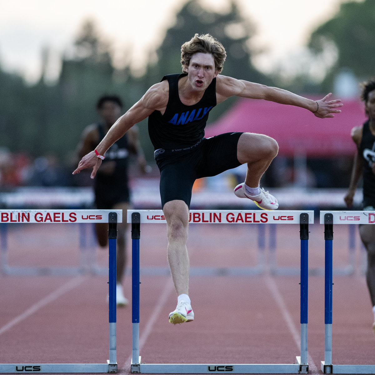 Track athlete leaping over hurdle