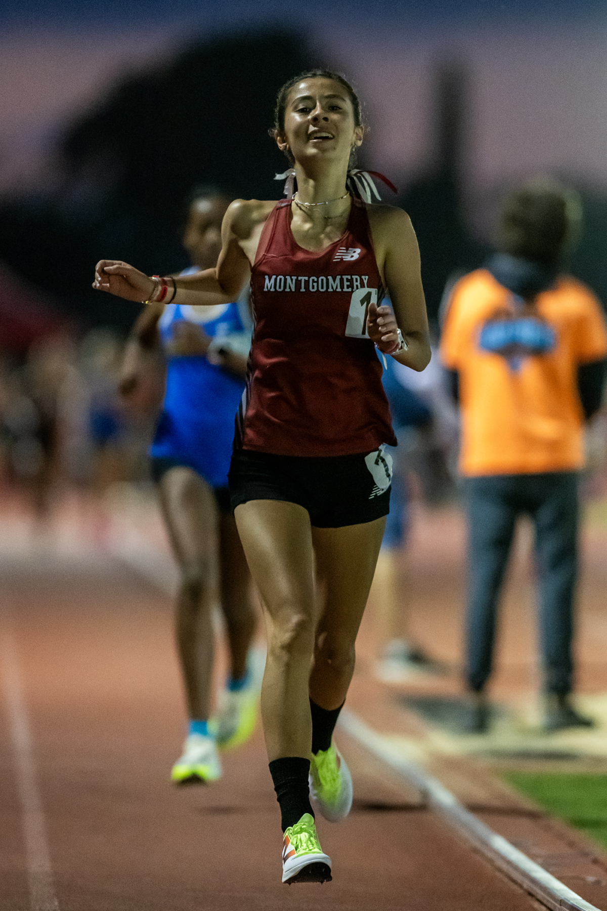 Female track athlete in Montgomery uniform sprinting