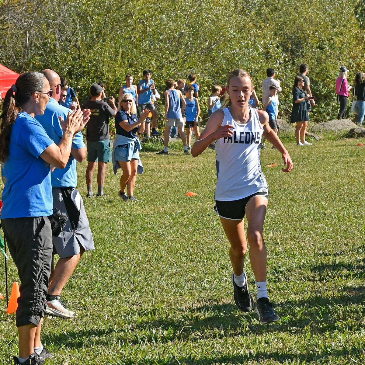 Cross-country runner sprinting past cheering spectators