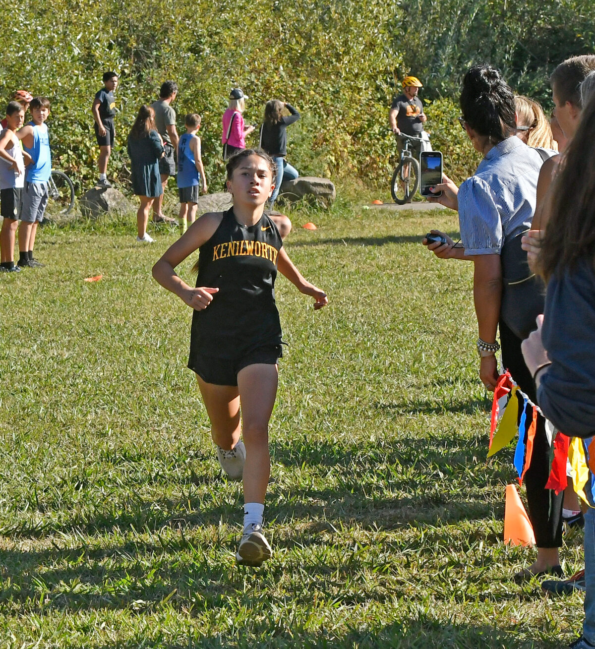 Cross-country runner approaching finish line with spectators