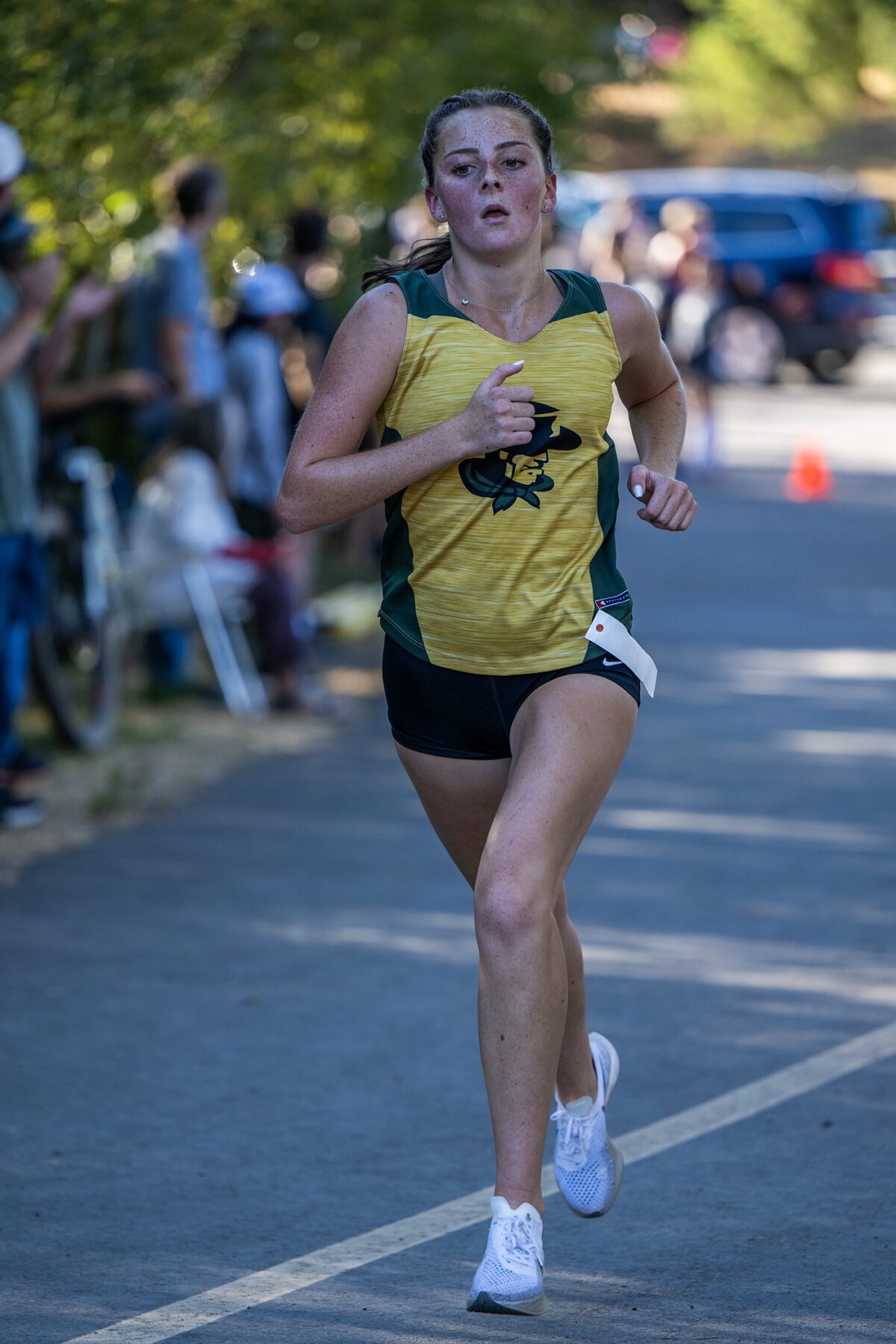 Runner sprinting in yellow uniform along road