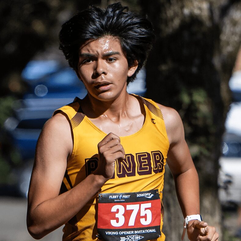 Young runner in yellow singlet racing