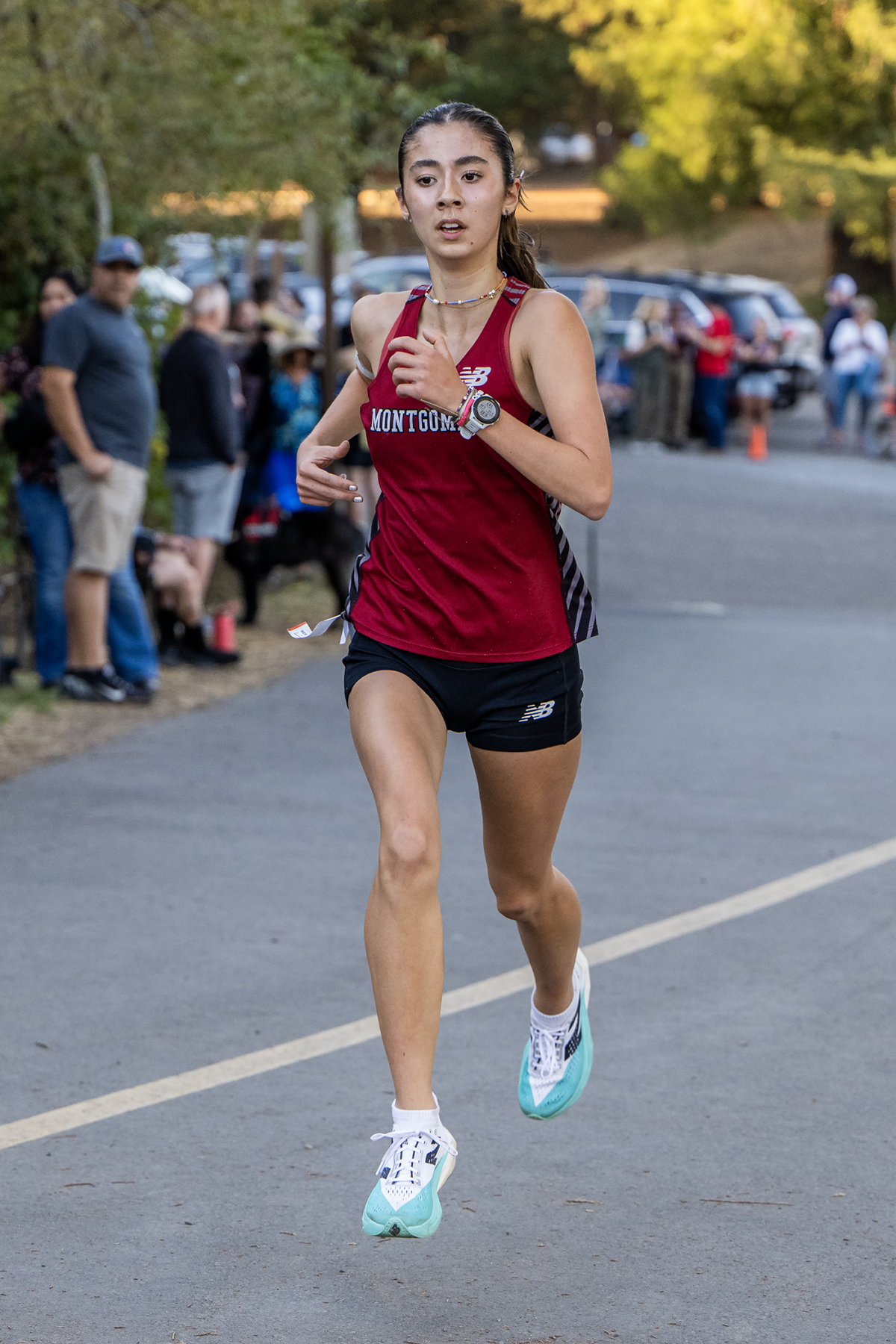 Female runner in maroon singlet on road