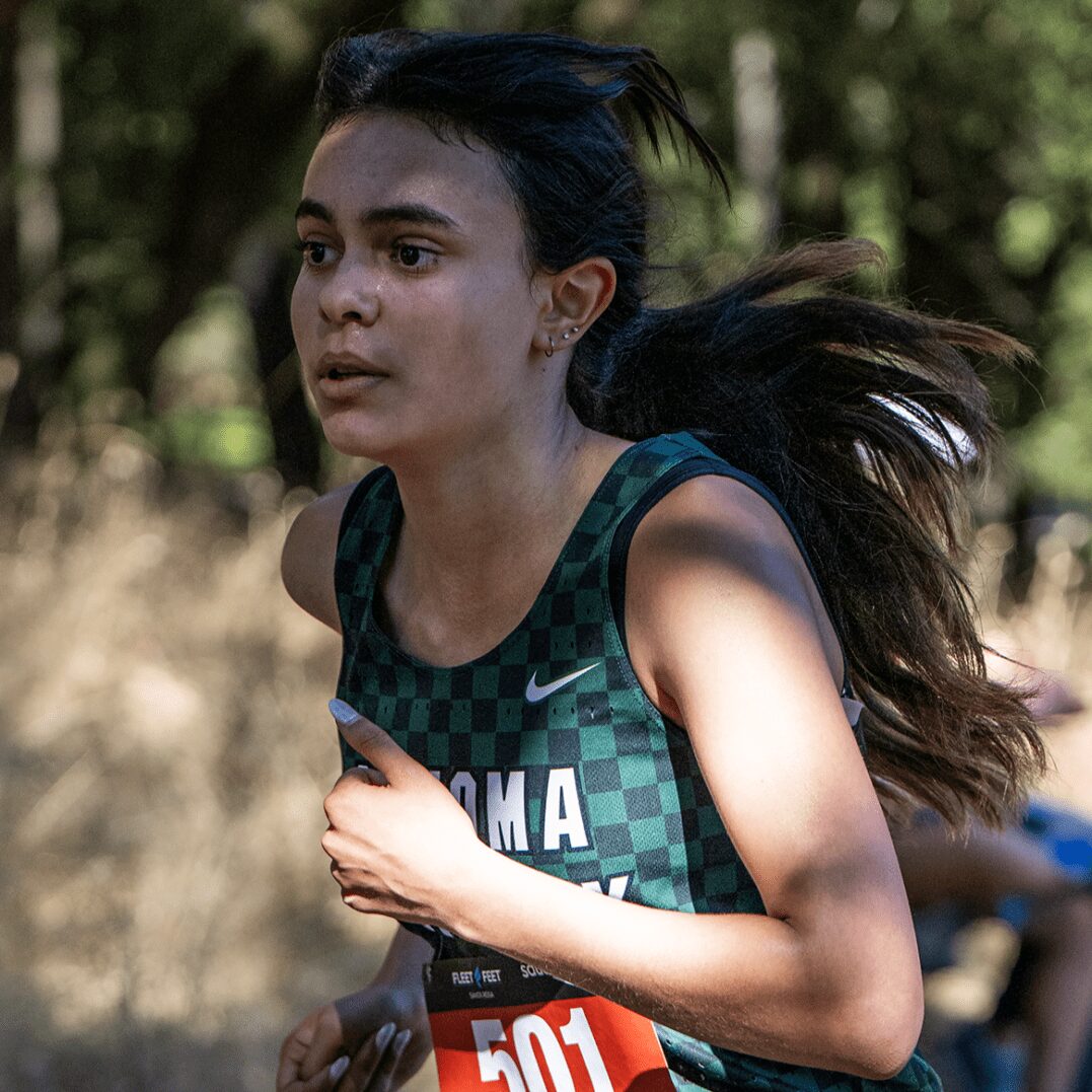 Athlete running in green checkered singlet, bib 501