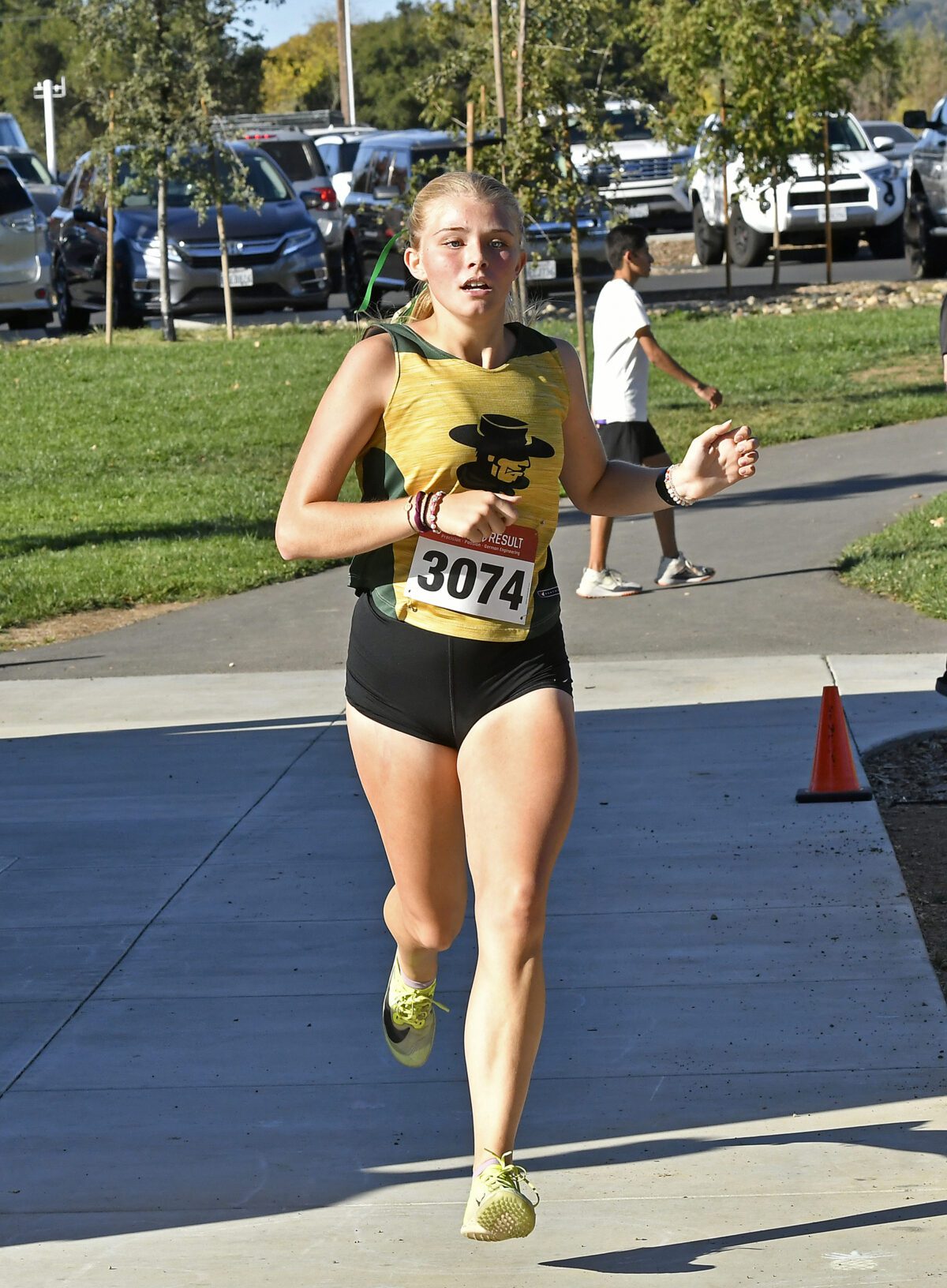 Runner wearing yellow top and race bib