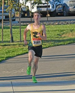Runner wearing yellow singlet and race bib