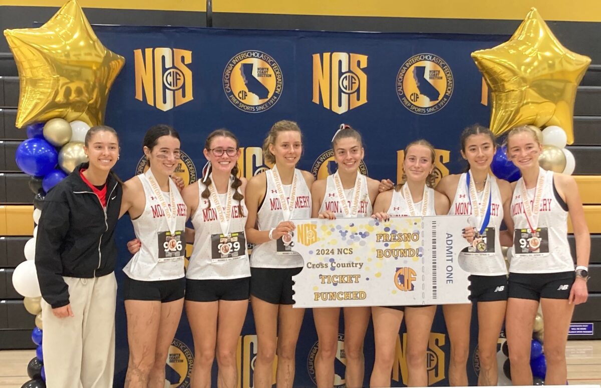 Girls cross country team with banner and medals