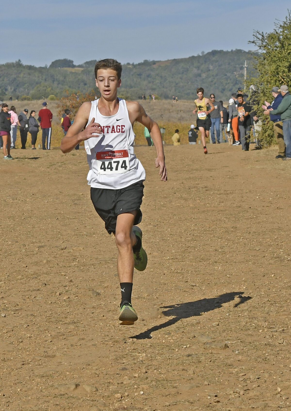 Teen runner sprinting on dirt cross-country course