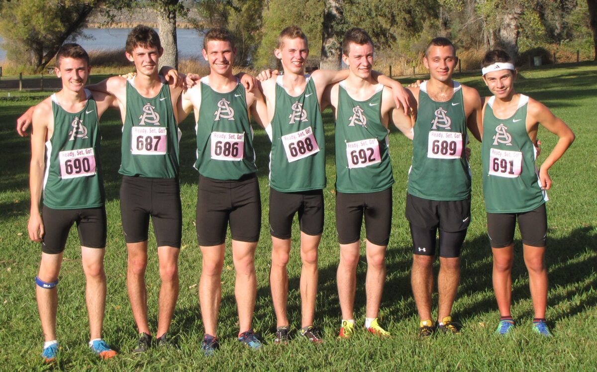 Seven cross-country runners in green uniforms