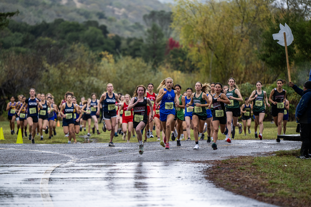 Cross-country race starters sprinting through rain