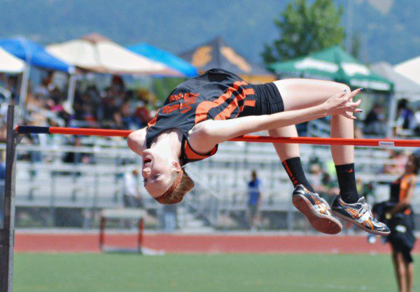High school athlete clearing high jump bar