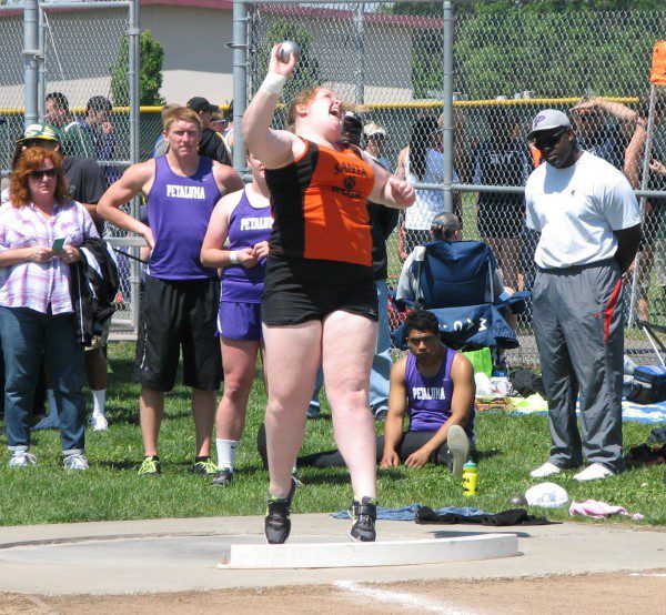 Woman throwing shot put at track meet