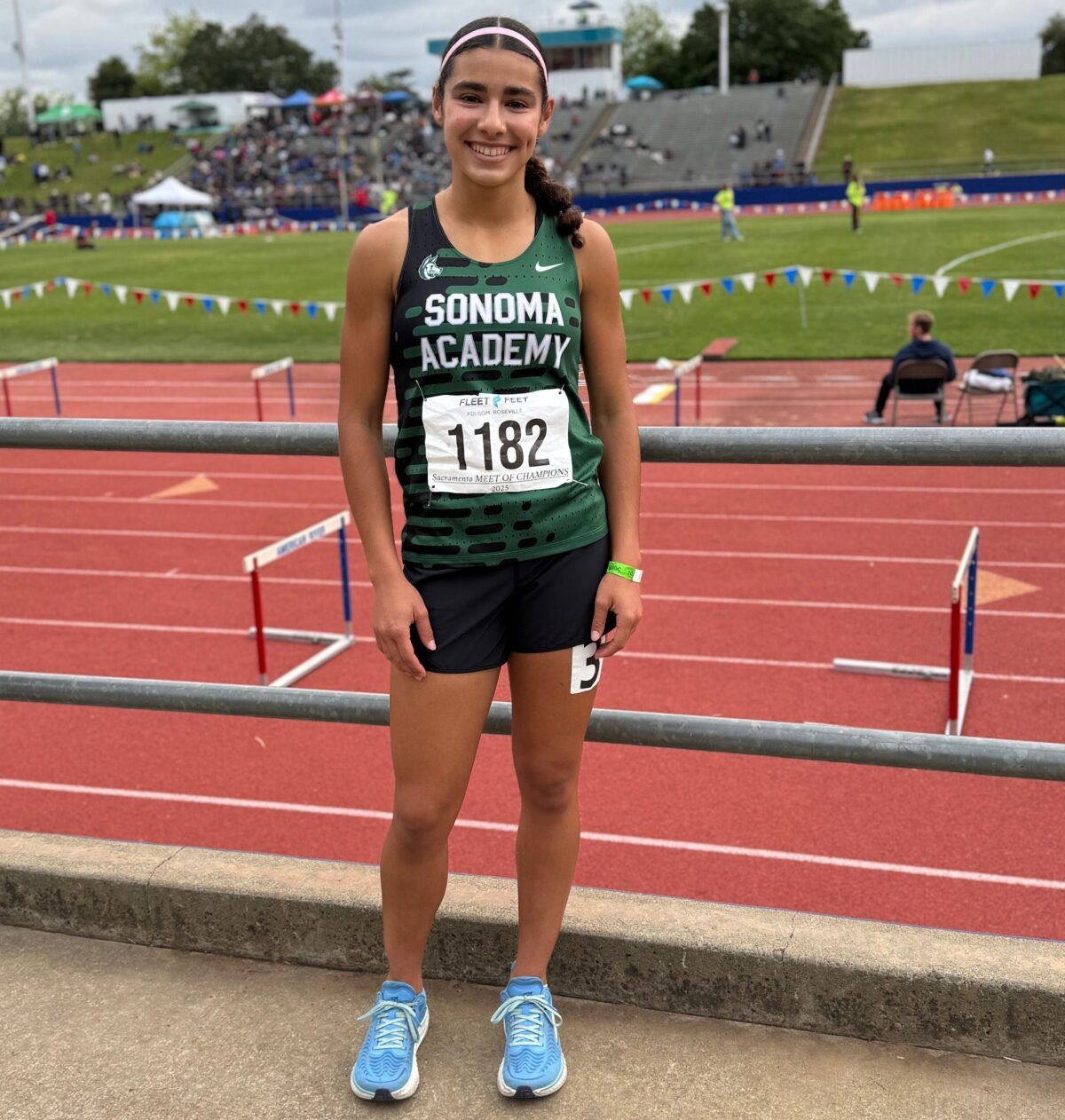Smiling athlete posing on trackside railing
