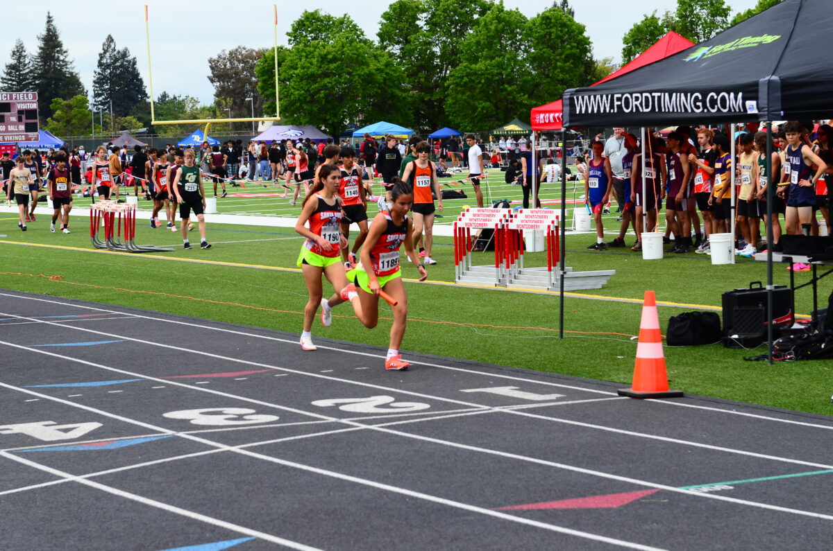 Two runners in neon shorts racing on track