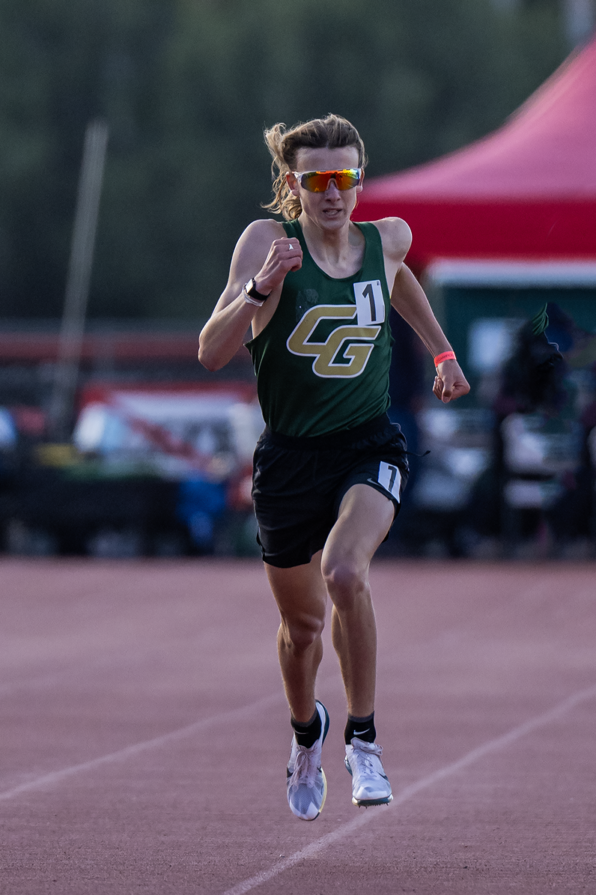Long-haired athlete in green racing mid-air