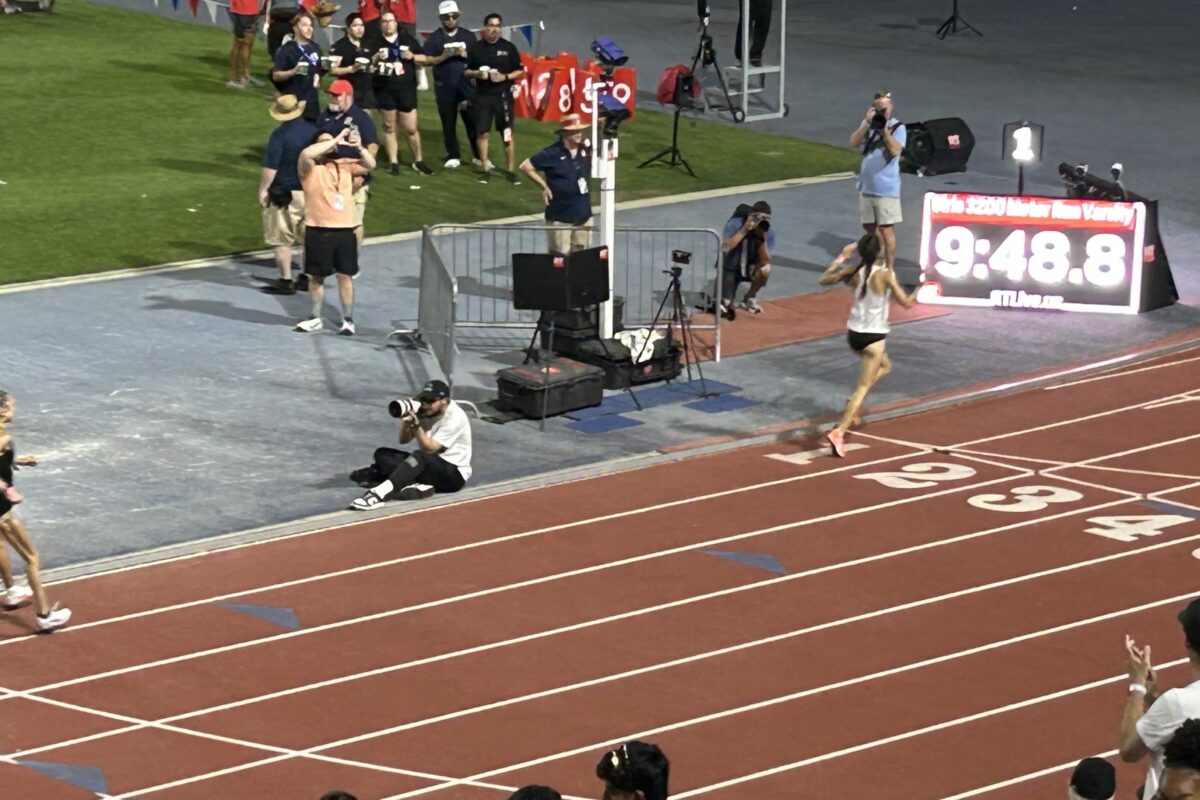 Solo runner nearing finish beside timing display