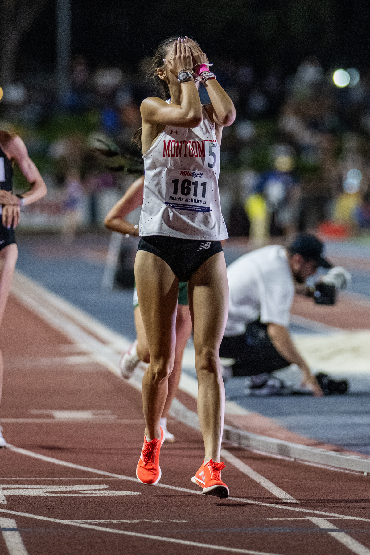 Exhausted track athlete covering face after race