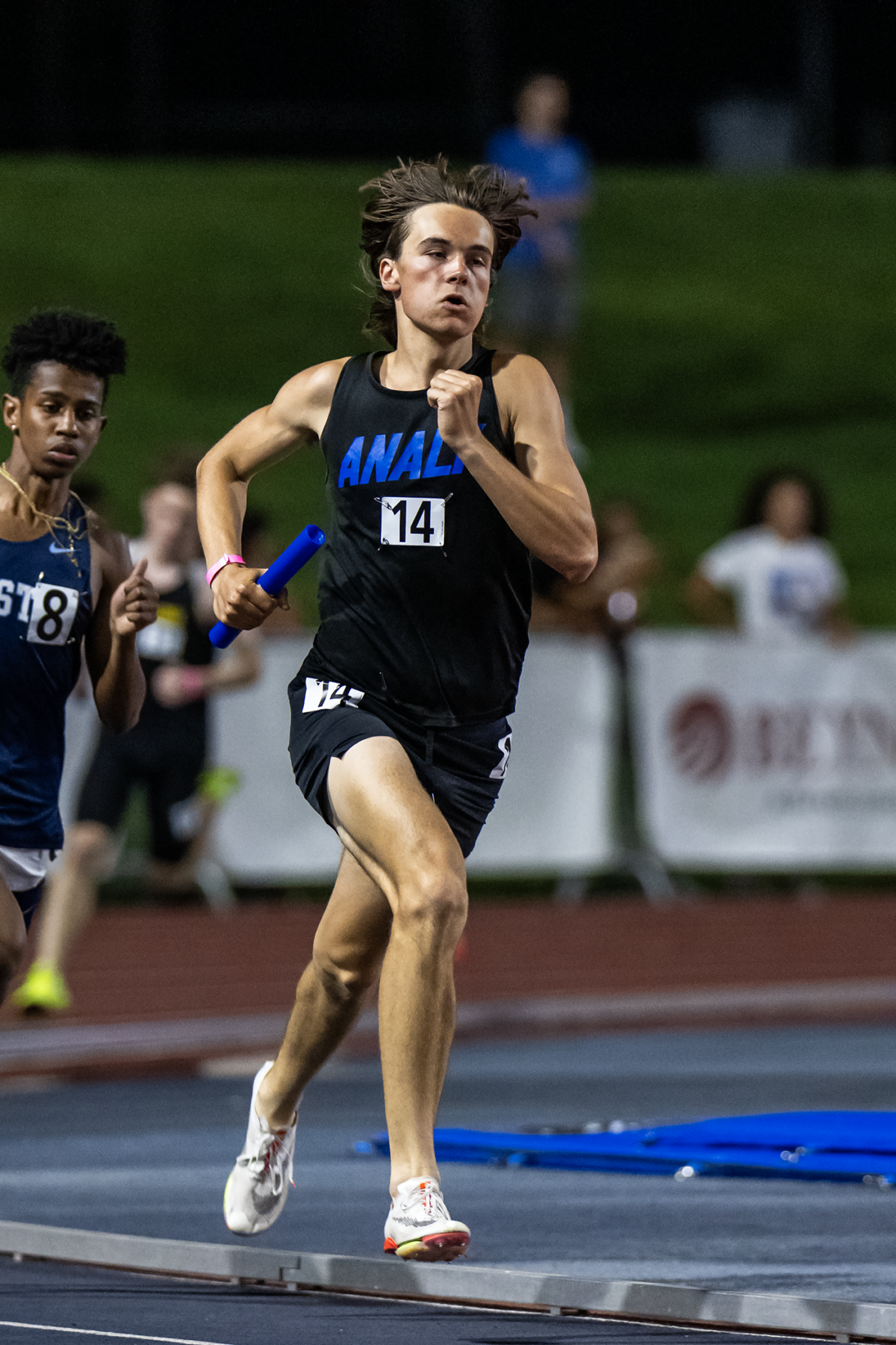 Relay runner with blue baton sprinting intensely