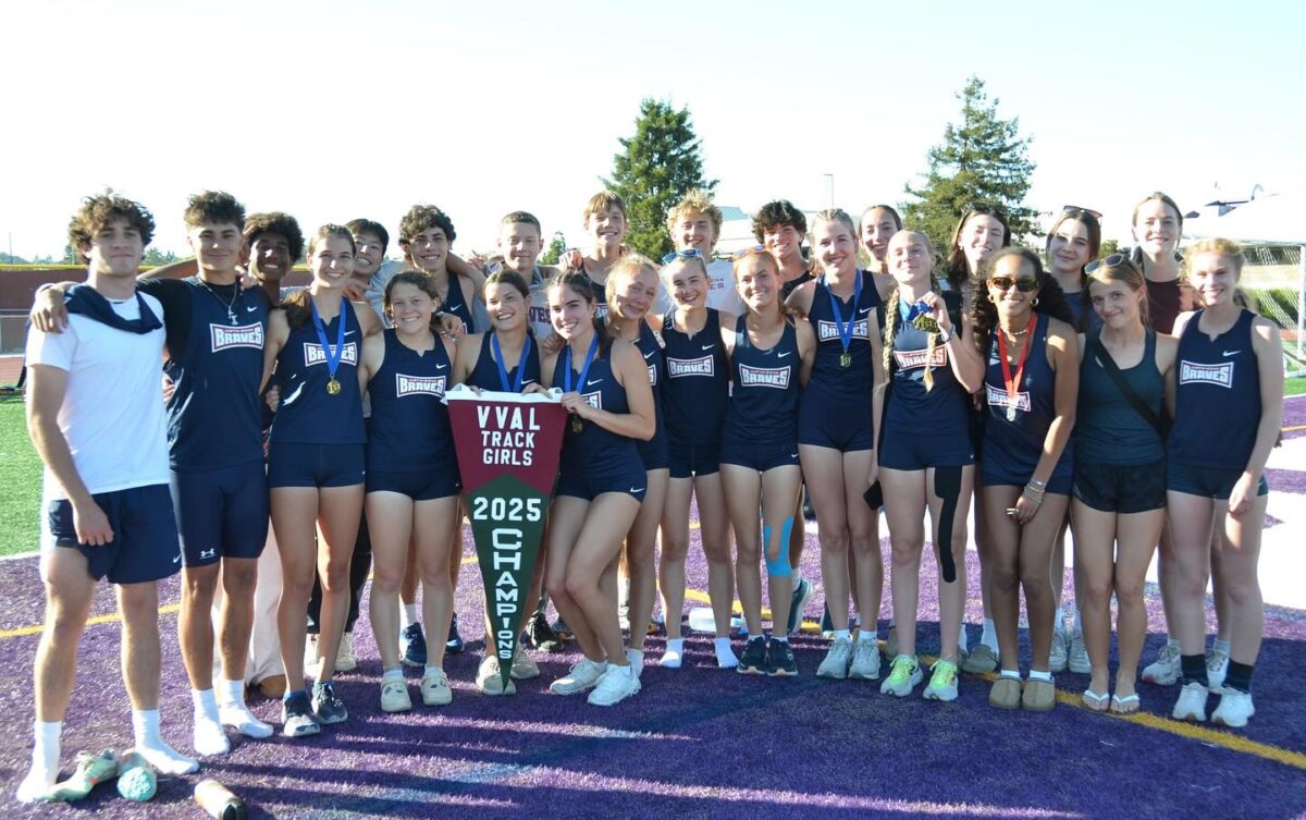 High school track athletes posing with championship pennant