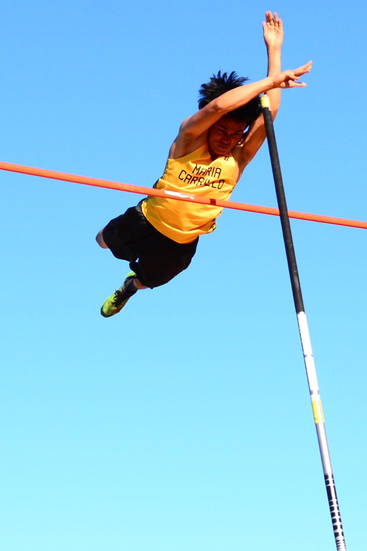 Yellow-clad athlete soaring horizontally skyward