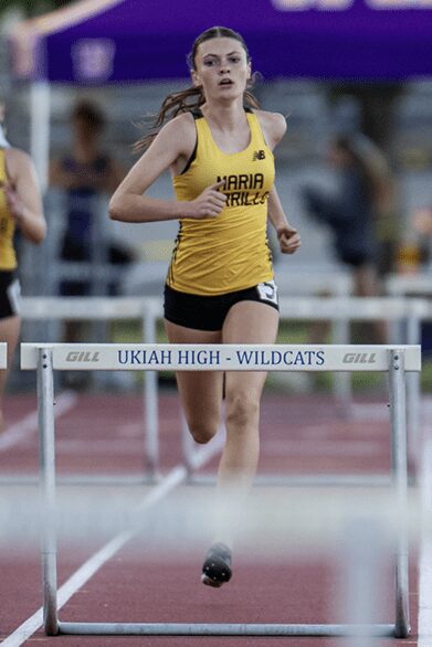 Female high school hurdler on track