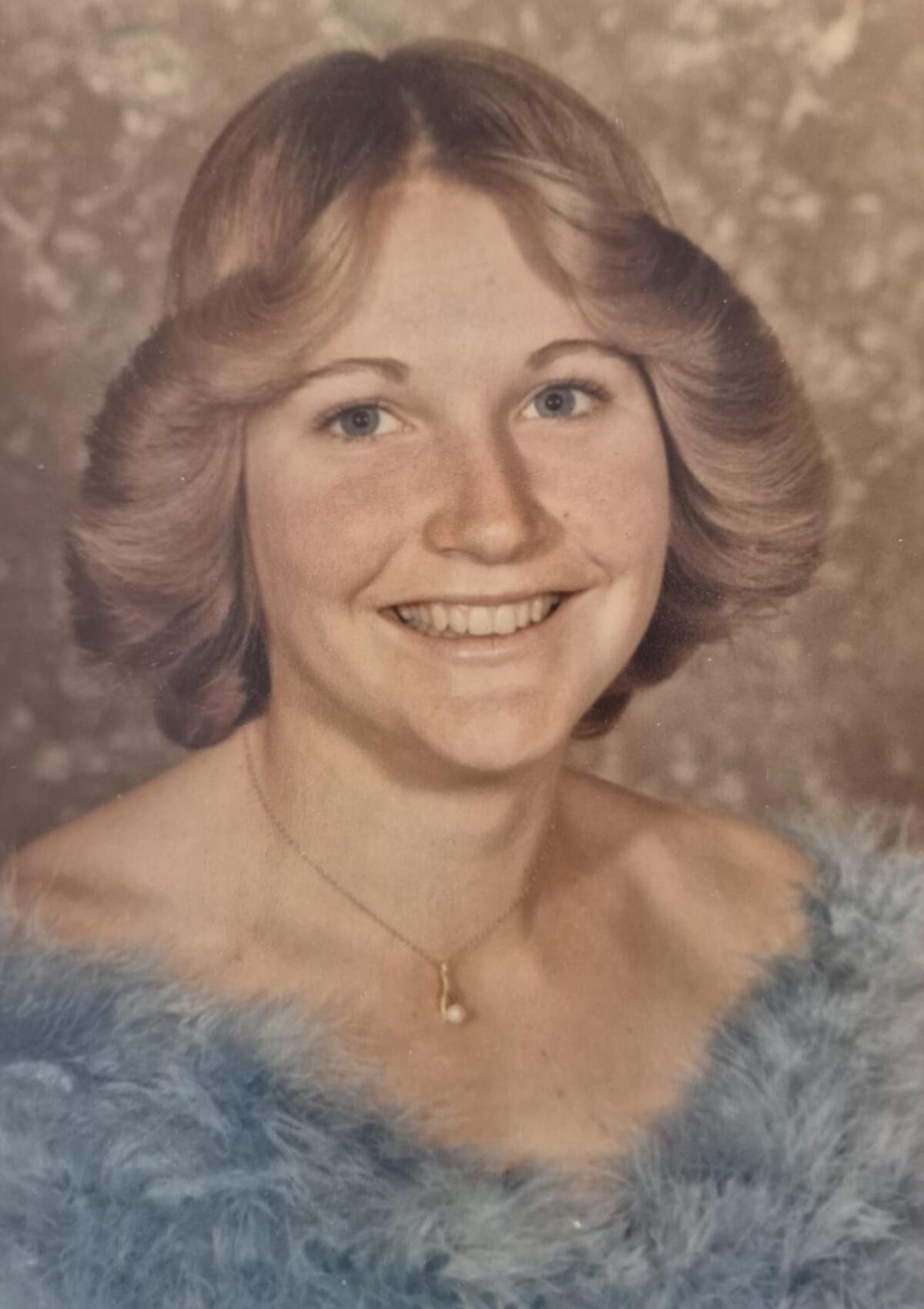 Smiling young woman in blue fur portrait
