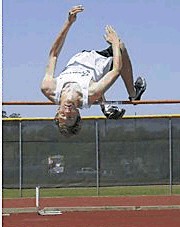 Athlete performing a high jump over the bar outdoors.