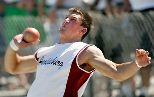 Athlete in mid-throw during a track and field event.