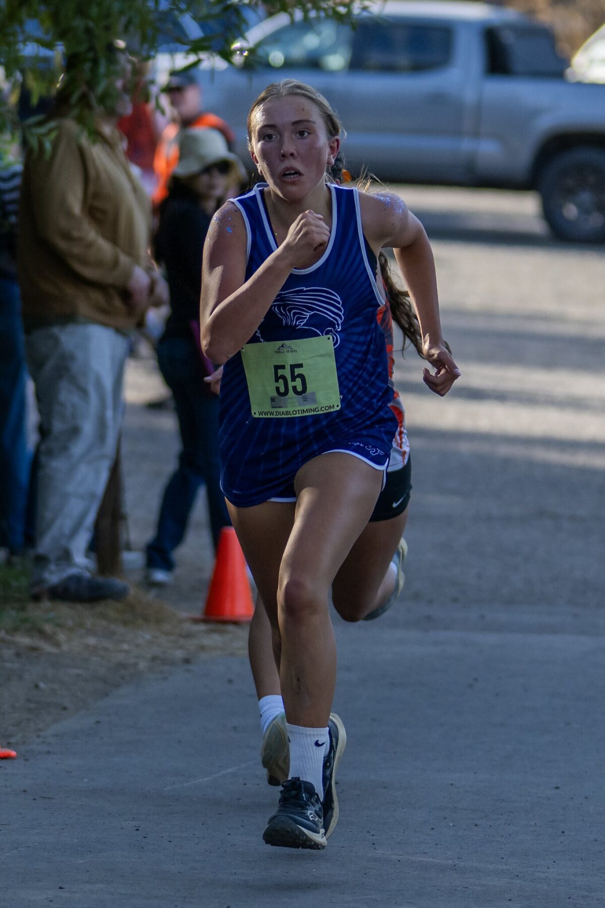 Runner in blue competing in a race outdoors.