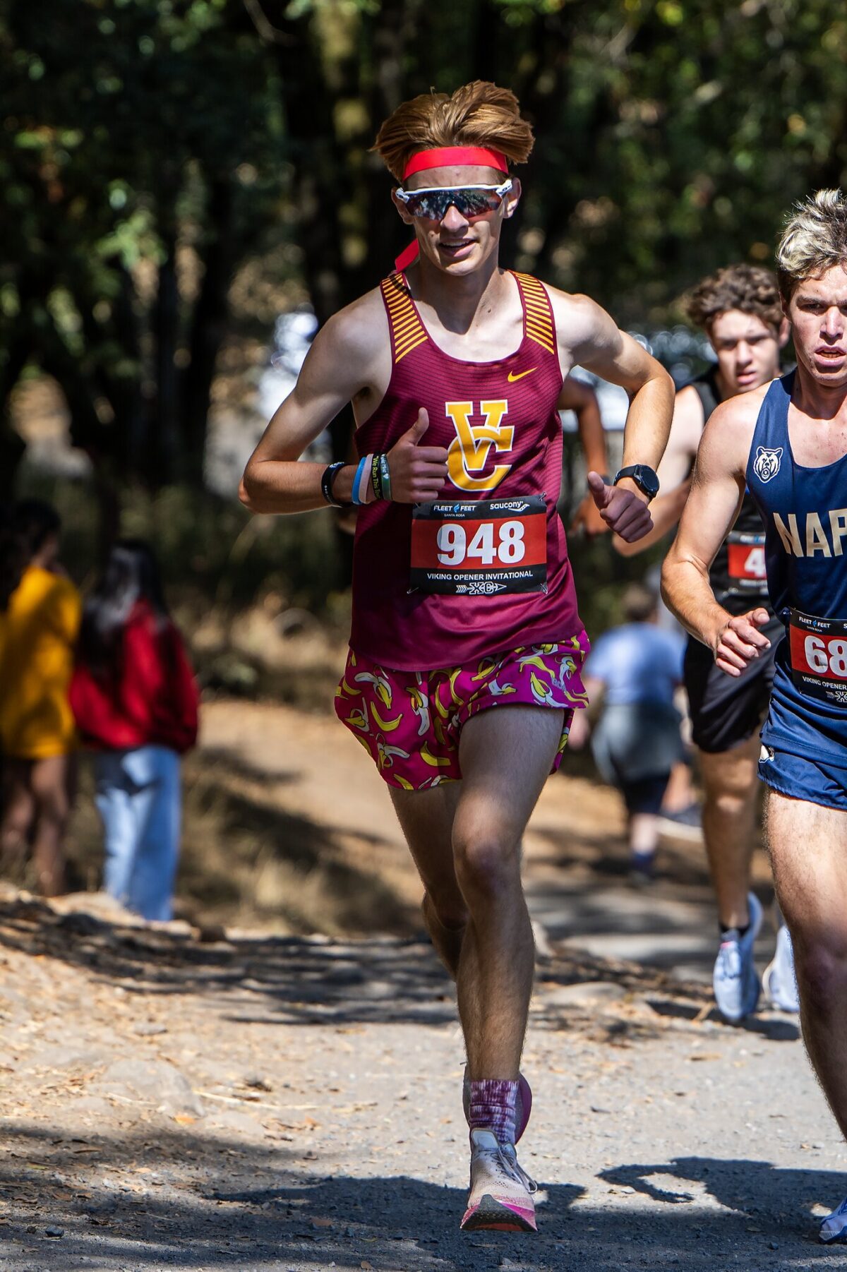 Runner wearing maroon and yellow gear competing in a race with bib number 948.