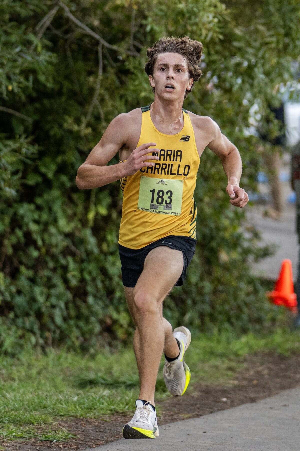 Cross-country runner in yellow jersey sprinting